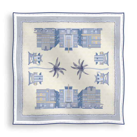 Cool Blue Miami Beach silk scarf featuring hand-drawn Art Deco buildings, iconic lifeguard towers, palm trees, and coastal scenery in shades of blue displayed in a lay-flat view.