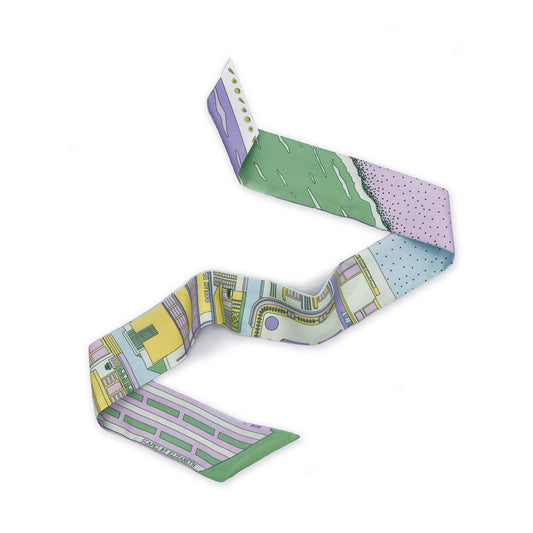Pastel Miami Beach silk twilly featuring hand-drawn illustrations of iconic Miami Beach Art Deco architecture and coastal scenery in soft pastel tones of purple, yellow, blue, and green displayed in a lay-flat view.