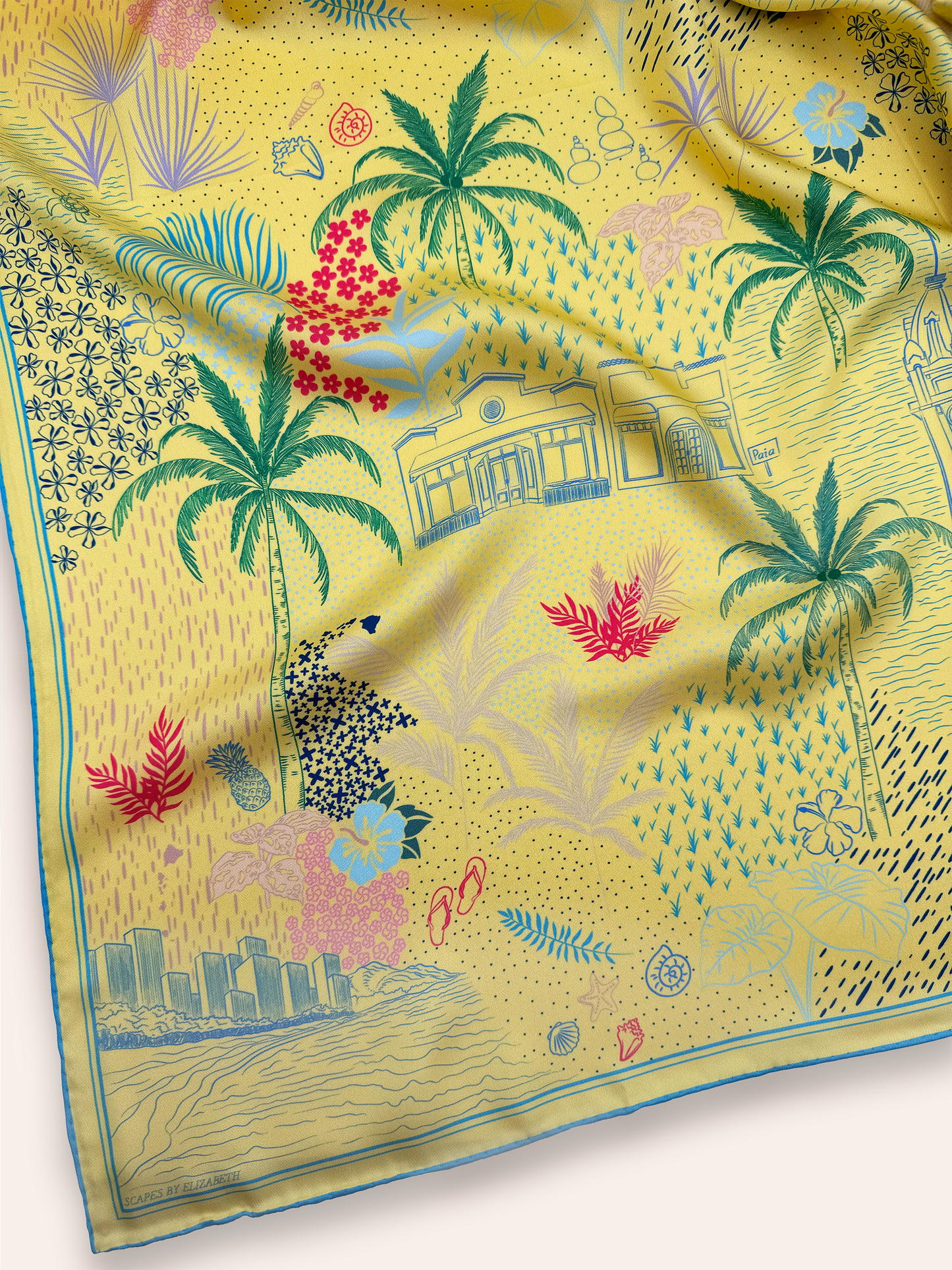 Close-up detail of the Pineapple Yellow Hawaii silk scarf showcasing hand-drawn Hawaiian Island icons, tropical florals, coastal elements, island landmarks, and intricate artwork inspired by Hawaii.