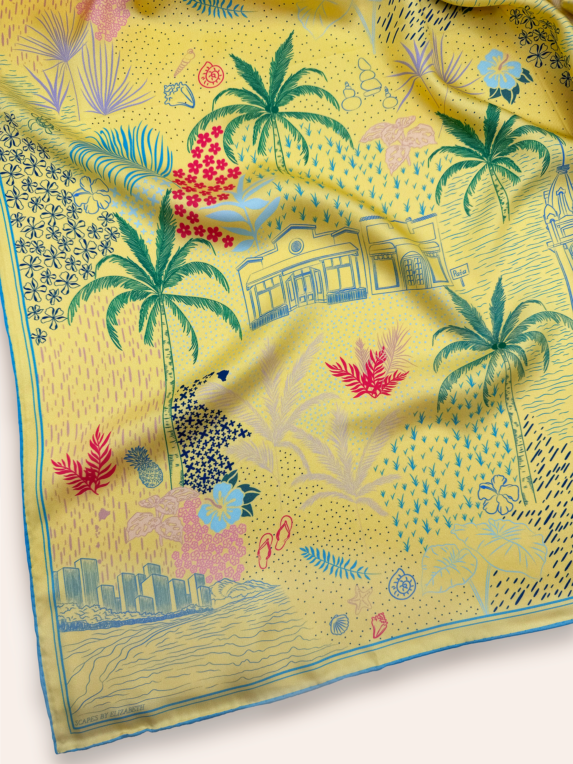 Close-up detail of the Pineapple Yellow Hawaii silk scarf showcasing hand-drawn Hawaiian Island icons, tropical florals, coastal elements, island landmarks, and intricate artwork inspired by Hawaii.