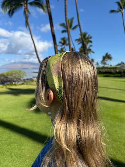 Woman wearing the Pineapple Yellow Hawaii silk twilly as a headband featuring colorful hand-drawn tropical flowers, coastal shells, ocean waves, and Hawaiian-inspired island motifs for a summer vacation outfit.