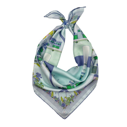 Seafoam Blue Key West silk scarf styled as a neck bandana featuring hand-drawn Key West architecture, Duval Street landmarks, tropical florals, and coastal-inspired artwork.