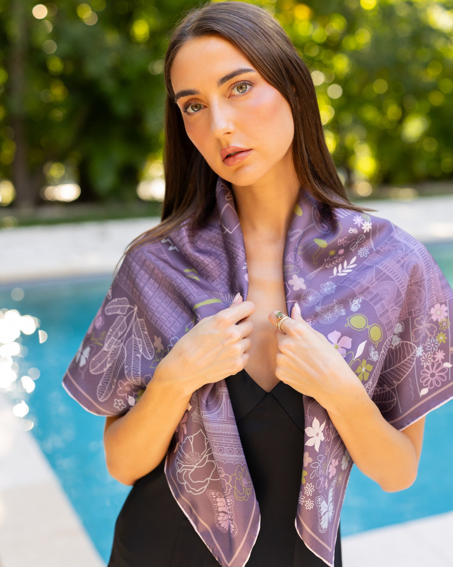 Purple, blue, and green Paris silk scarf featuring a hand-drawn map of Paris with iconic landmarks including the Eiffel Tower, Moulin Rouge, and Arc de Triomphe, styled as a shawl.
